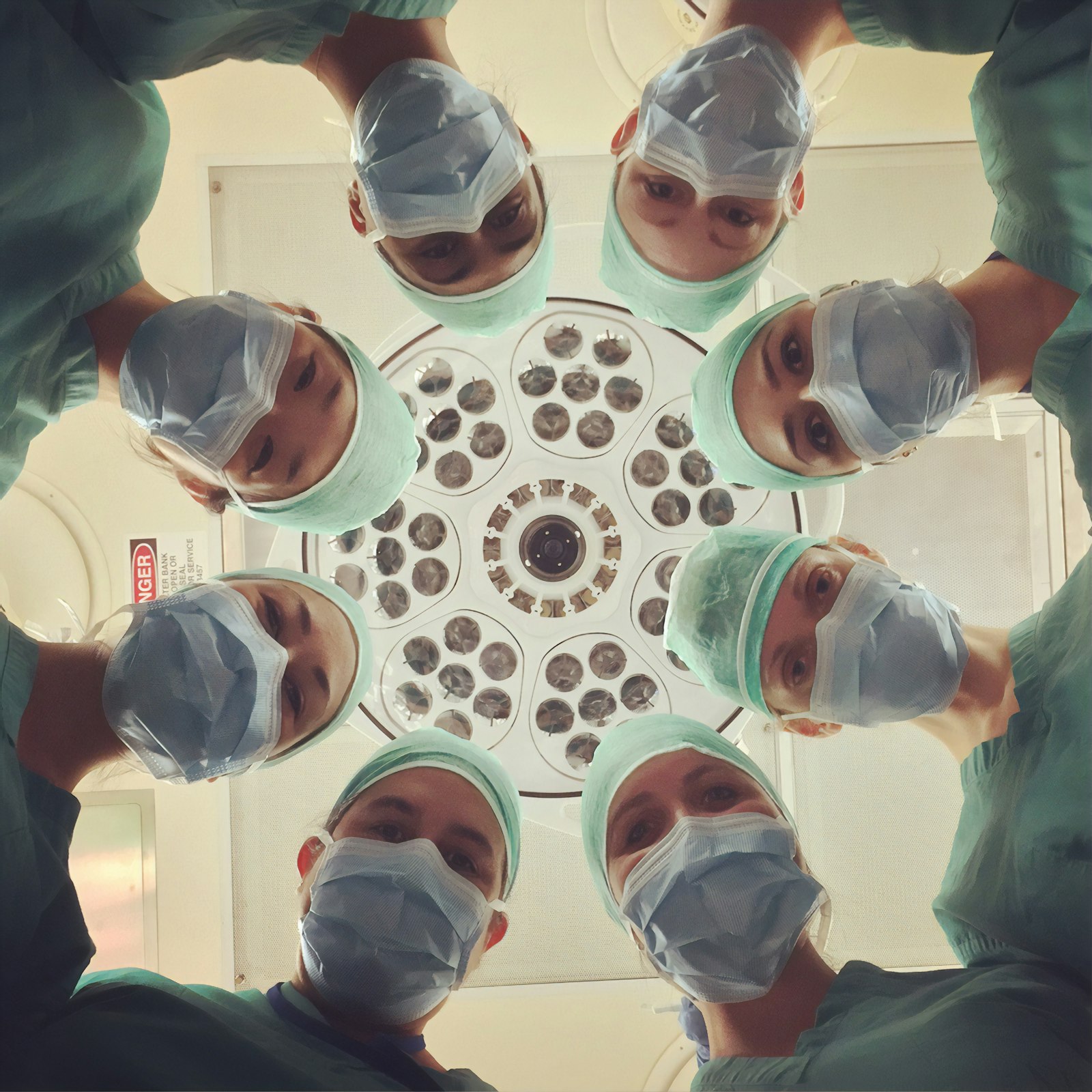 Team of healthcare professionals in surgical dress, viewed from below