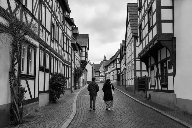 A cobbled street in a historic German town lined with half-timbered houses
